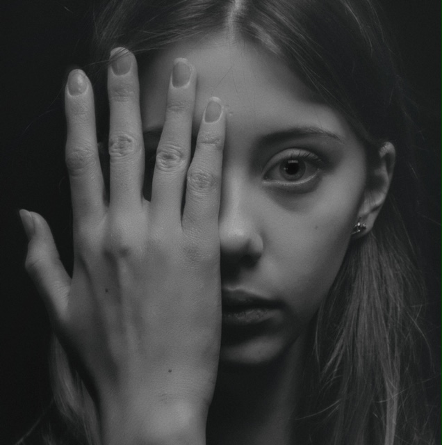 black and white child with half face covered by hand